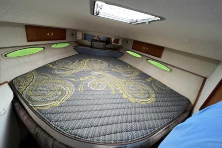 A comfortable Fox mattress installed in a compact RV sleeping area with built-in storage and windows for natural light.