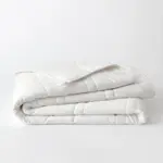Soft white comforter on a plain background, ideal for sleep comfort, bedding, and mattress support. Perfect for improving sleep quality and mattress longevity.
